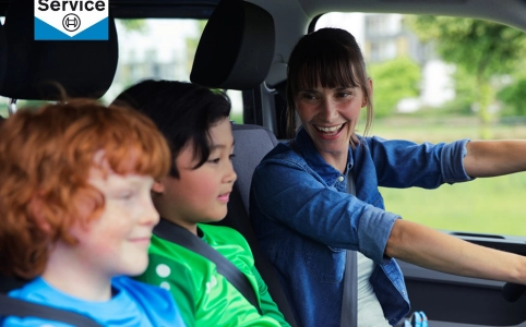 kobieta z dziećmi jadą samochodem